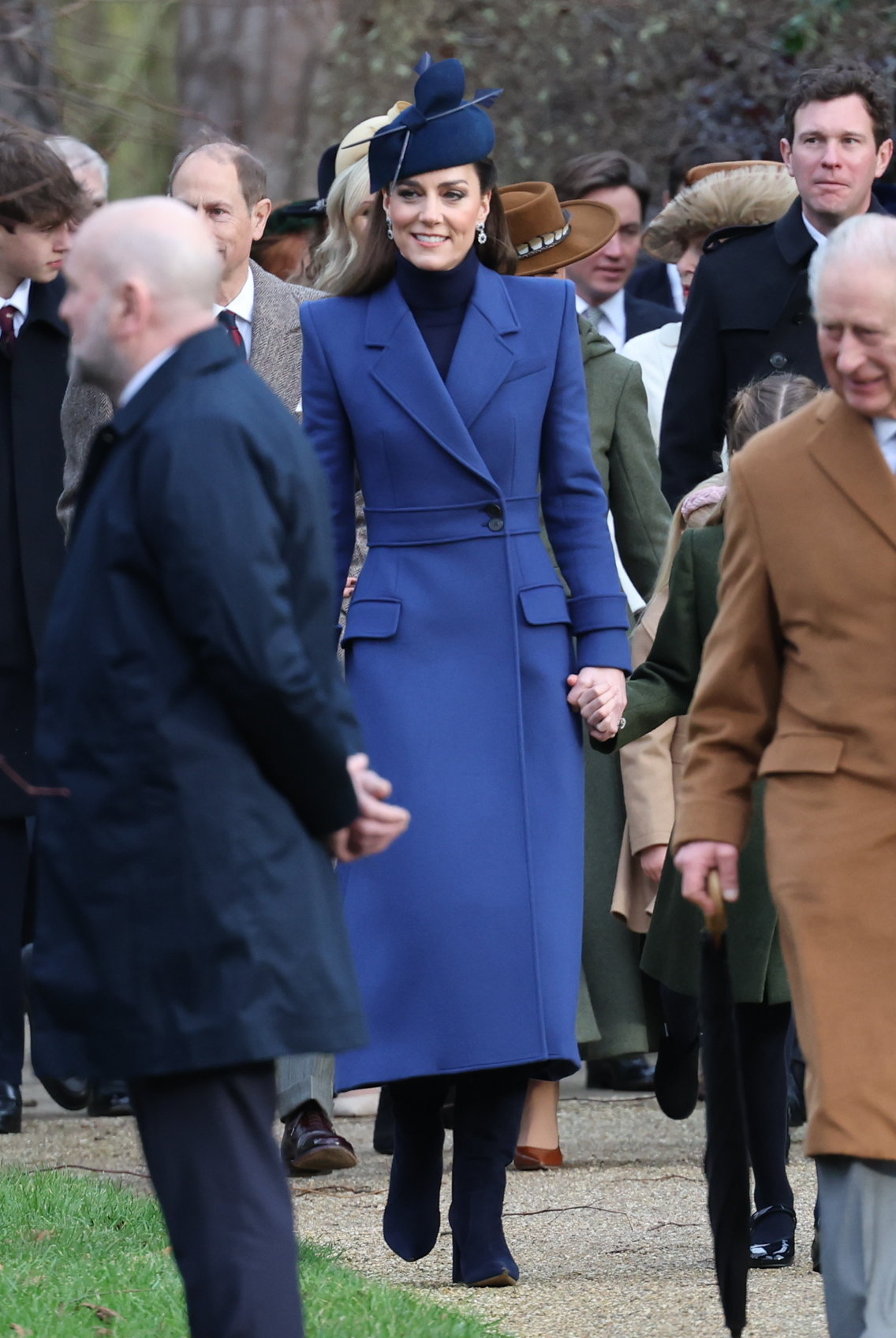 Kate stupéfaite dans un manteau bleu et un chapeau