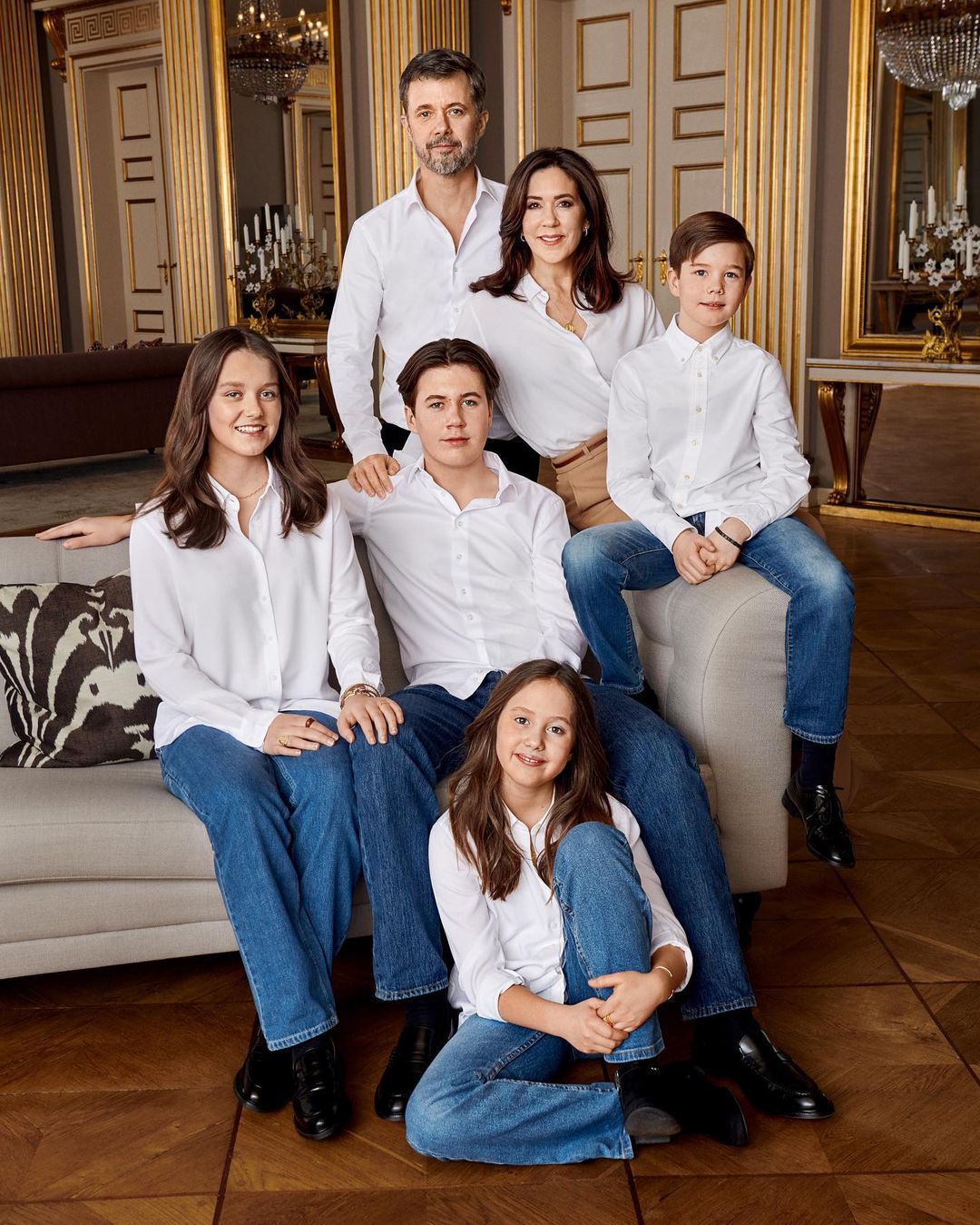 Frederik et Mary avec leurs enfants vêtus de chemises blanches et de jeans bleus assortis