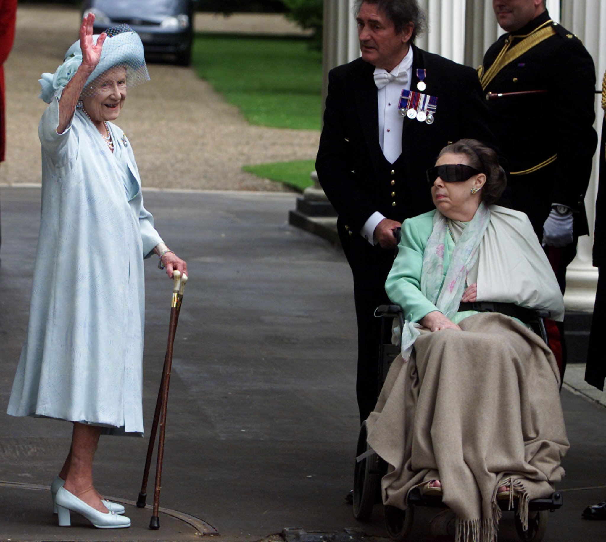 The Queen Mother waves to supporters as Margaret looks on in a wheelchair in August 2001, after suffering a stroke which impaired her vision