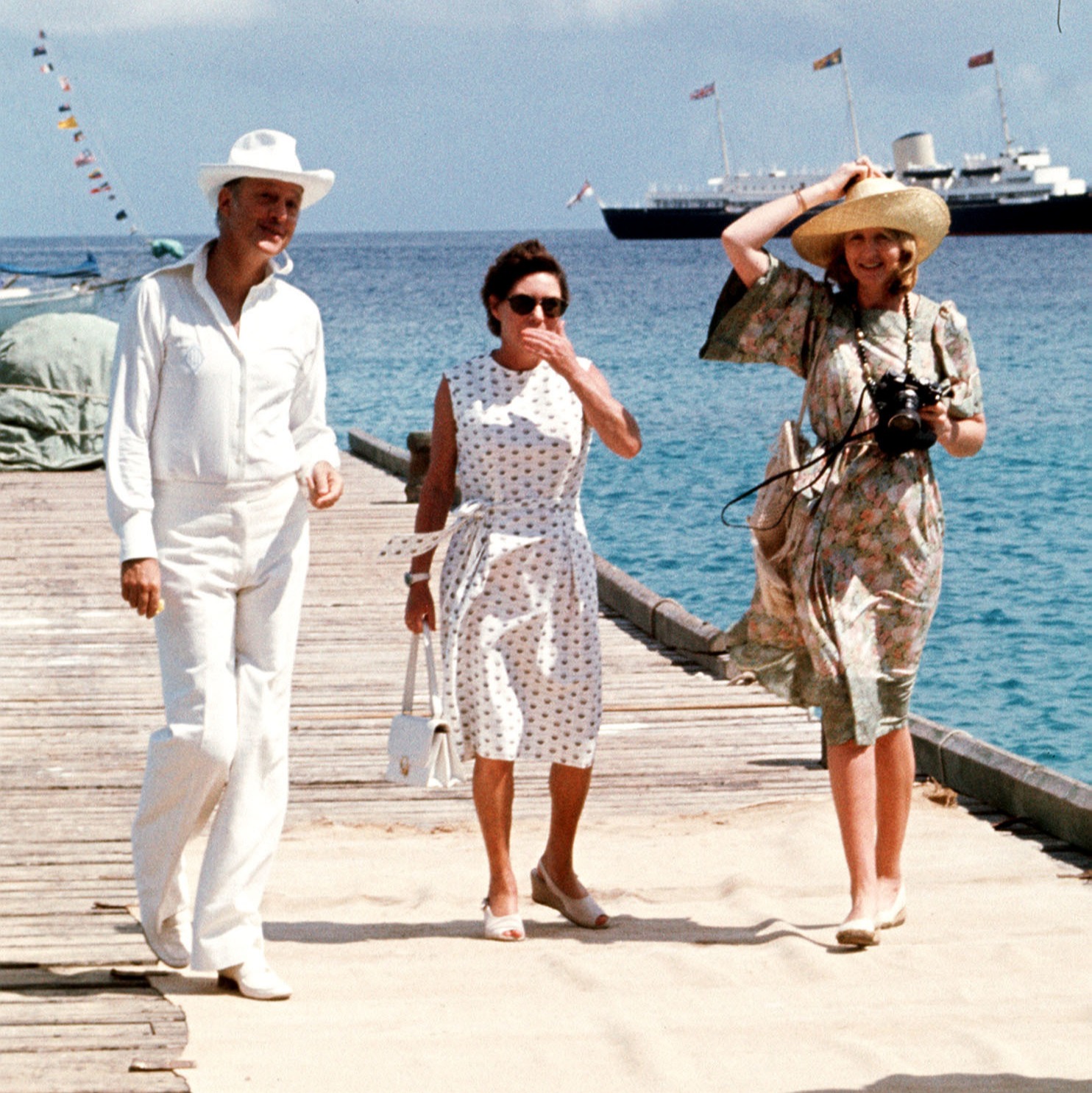The princess, pictured centre, and her friends Lord Colin Tennant and Lady Anne Tennant are seen waiting on the jetty at Mustique to greet the Queen during her Silver Jubilee tour of the West Indies