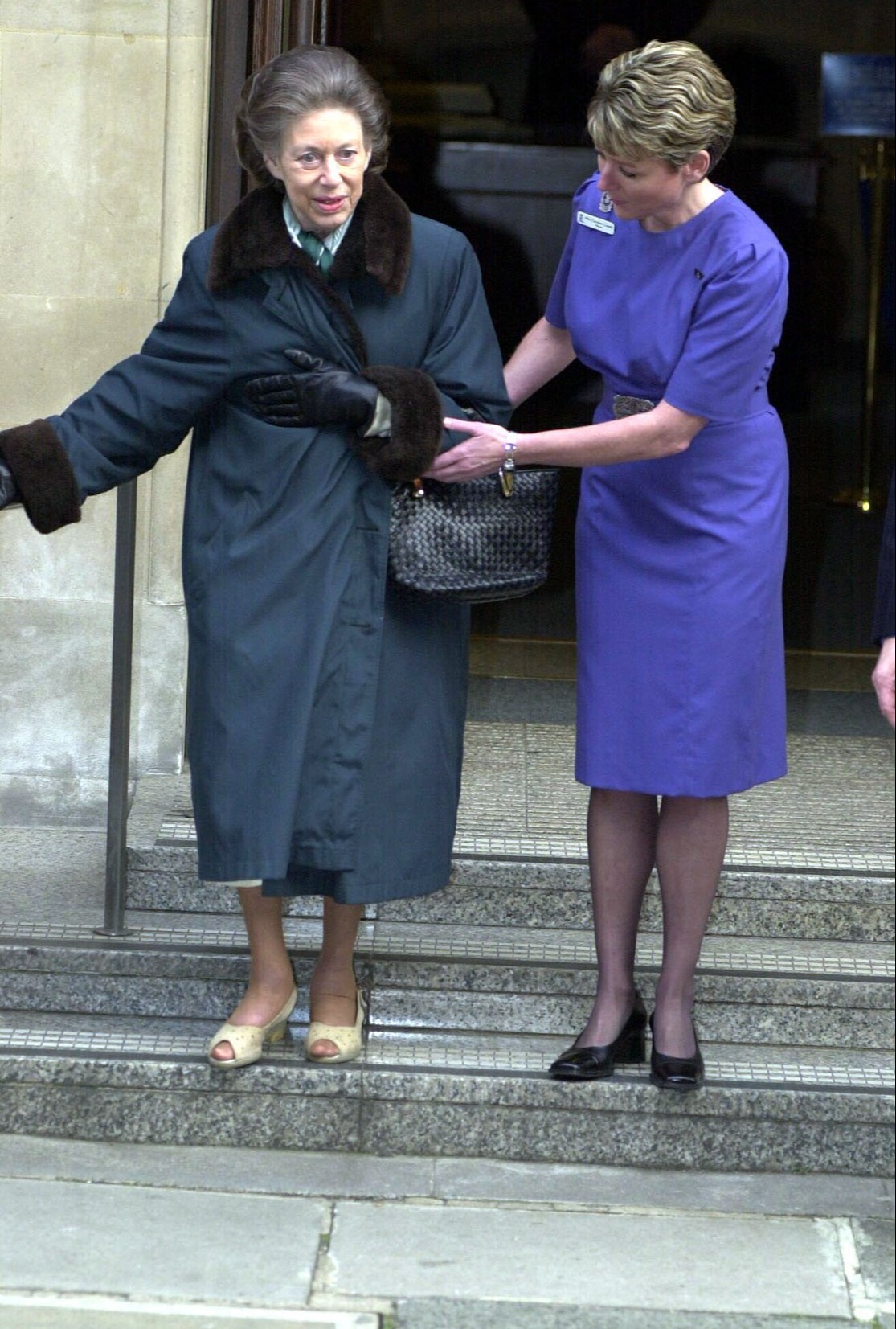 Margaret is helped down a flight of steps by a nurse as she leaves King Edward VII Hospital in London in January 2001