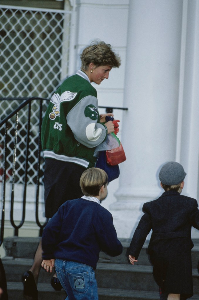La princesse Diana dans une veste des Eagles accompagne ses deux enfants dans les escaliers d'une école