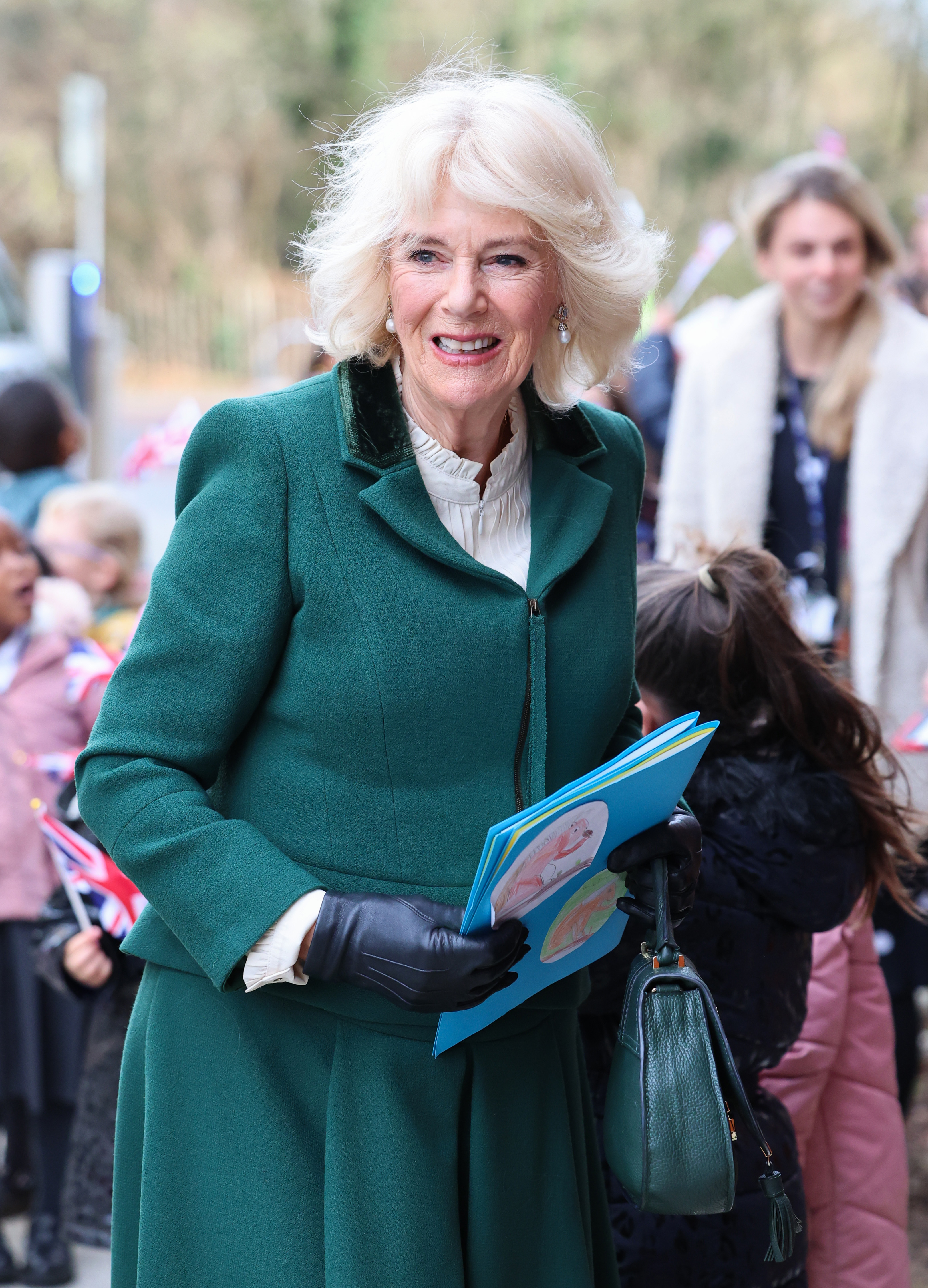 La reine Camilla sourit alors qu'elle arrive pour sa visite au centre communautaire Meadows récemment ouvert au début du mois.