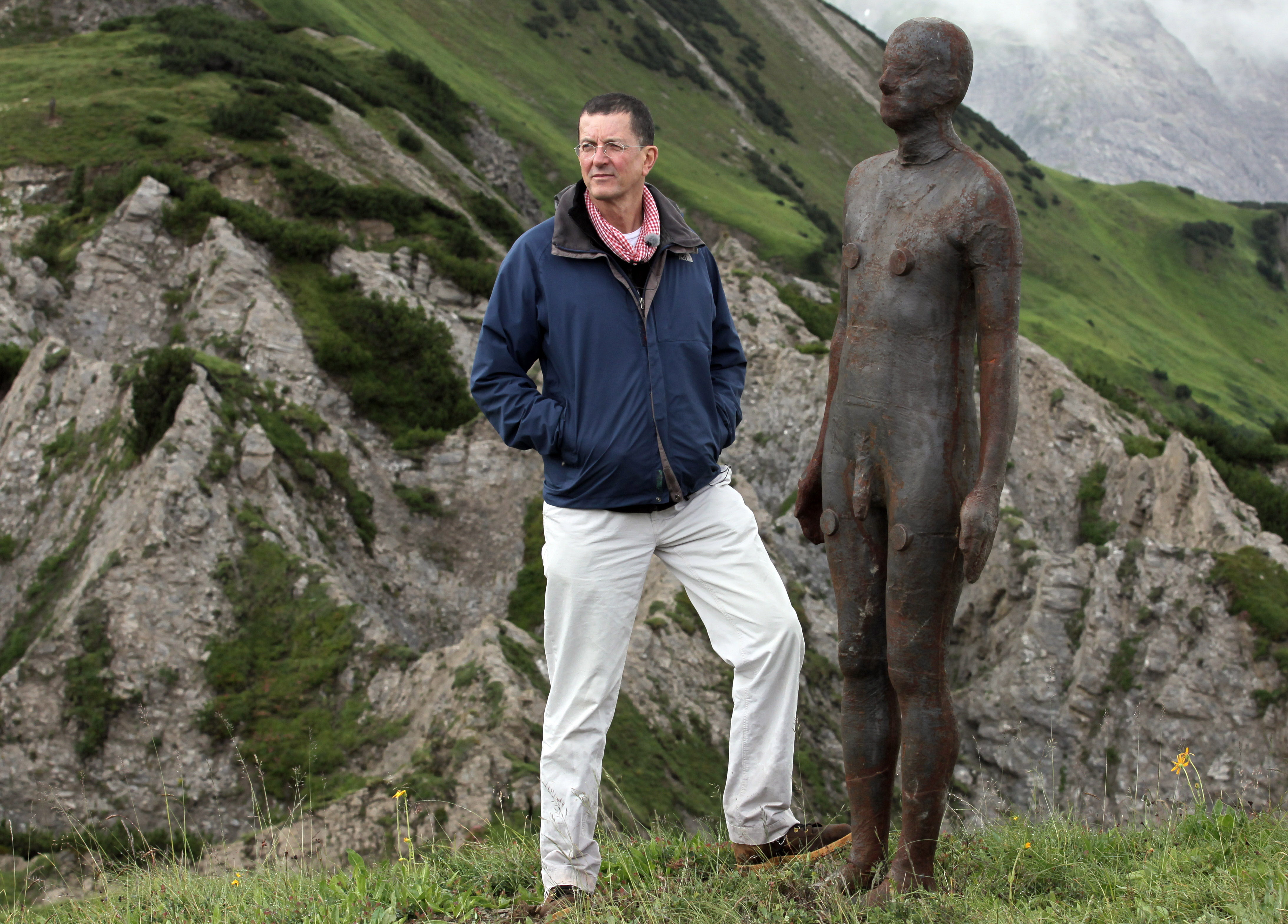 Sir Antony pose à côté d'une figure en bronze grandeur nature près de l'alpage de Kriegeralpe dans le village autrichien de Lech am Arlberg le 30 juillet 2010.